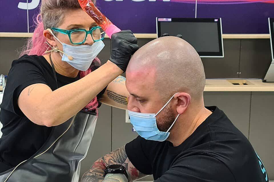 A Foli Sim artist applying scalp micropigmentation to a client